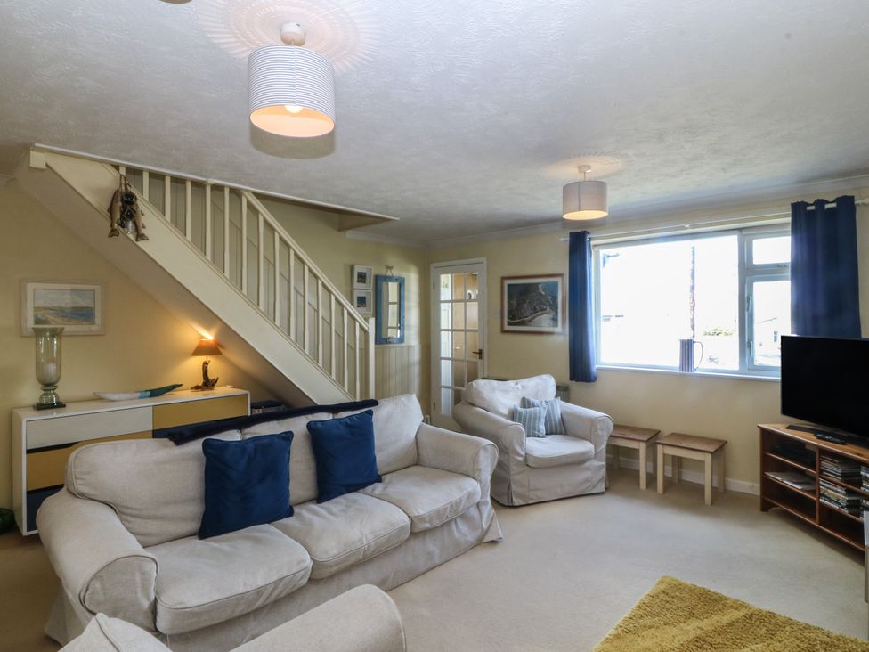 A living room with a sofa and TV at Wingelock in Rhosneigr