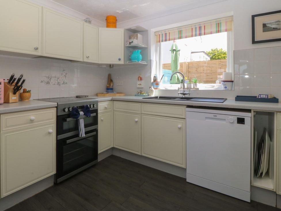 A kitchen with cabinets, oven, sink, and dishwasher at Wingelock in Rhosneigr