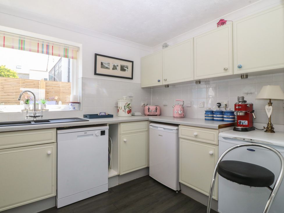 A kitchen with appliances and storage at Wingelock in Rhosneigr