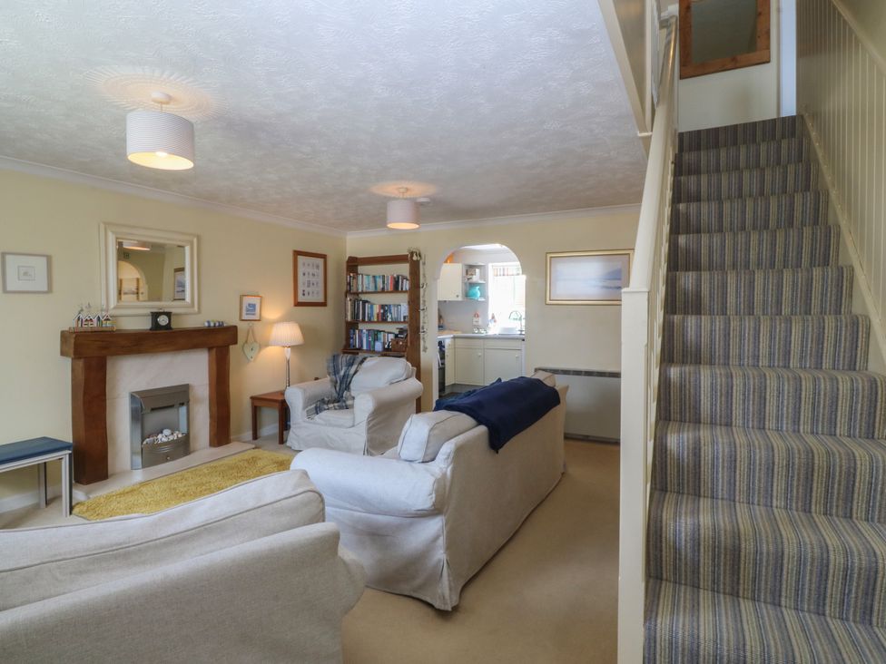 A living room with a fireplace and bookshelves at Wingelock in Rhosneigr