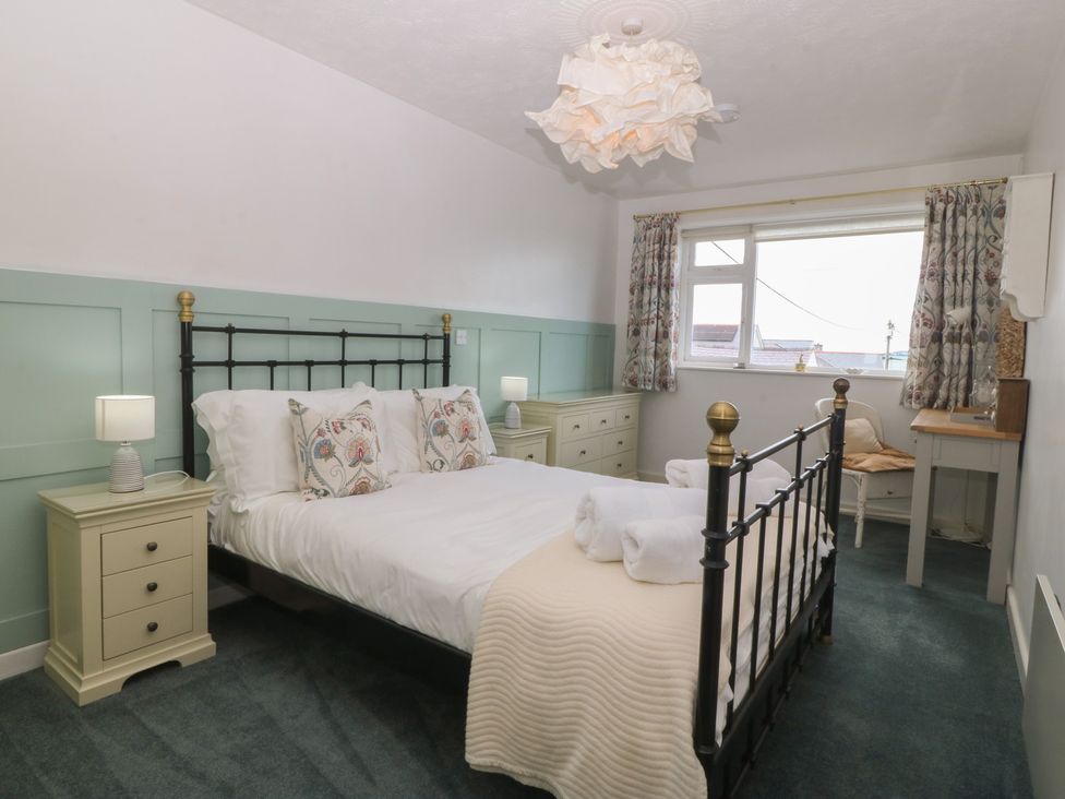 A bedroom with a bed and bedside tables at Wingelock in Rhosneigr