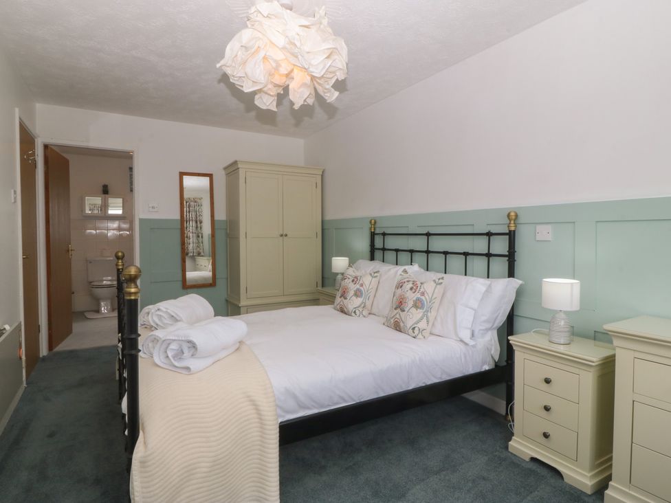 A bedroom with a bed and wardrobe at Wingelock in Rhosneigr