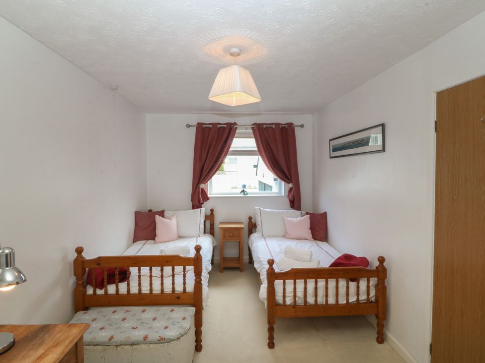 A bedroom with two beds and a bedside table at Wingelock in Rhosneigr