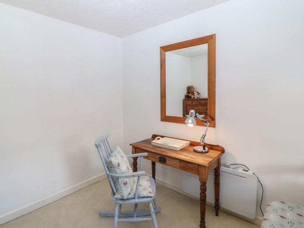 A bedroom with a desk and lamp at Wingelock in Rhosneigr