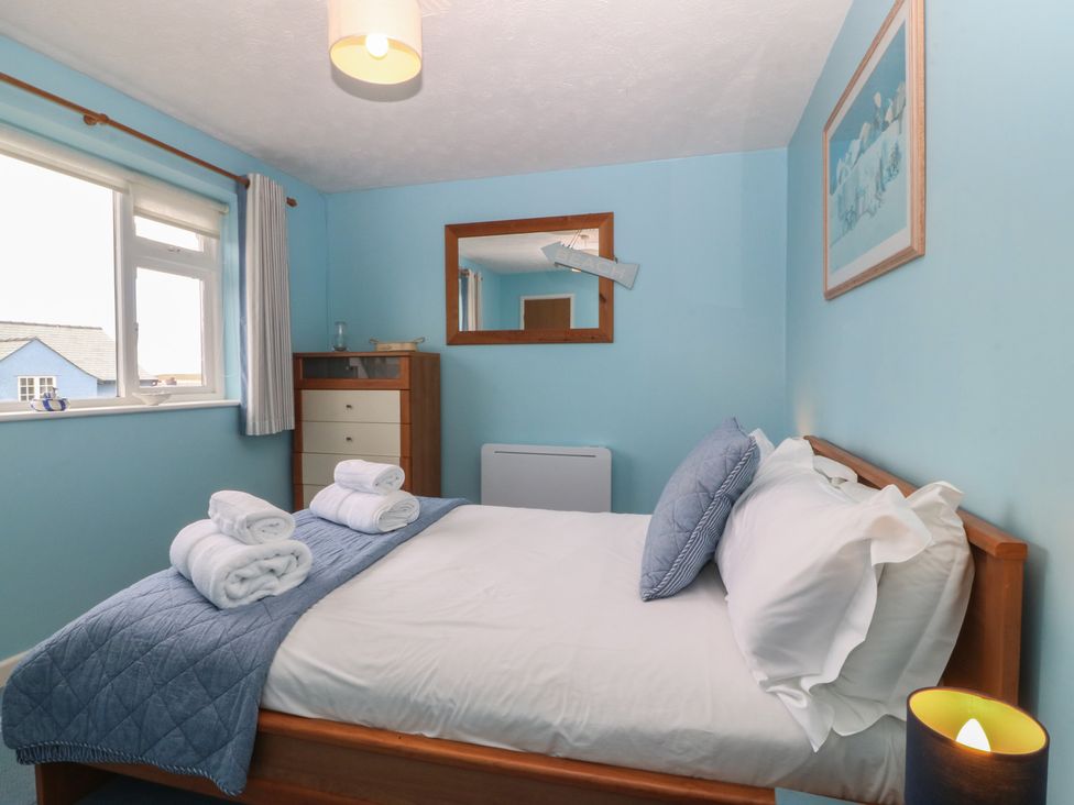A bedroom with a bed and dresser at Wingelock in Rhosneigr