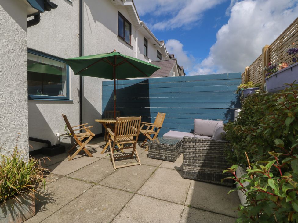 An outdoor seating area with a table and chairs at Wingelock in Rhosneigr