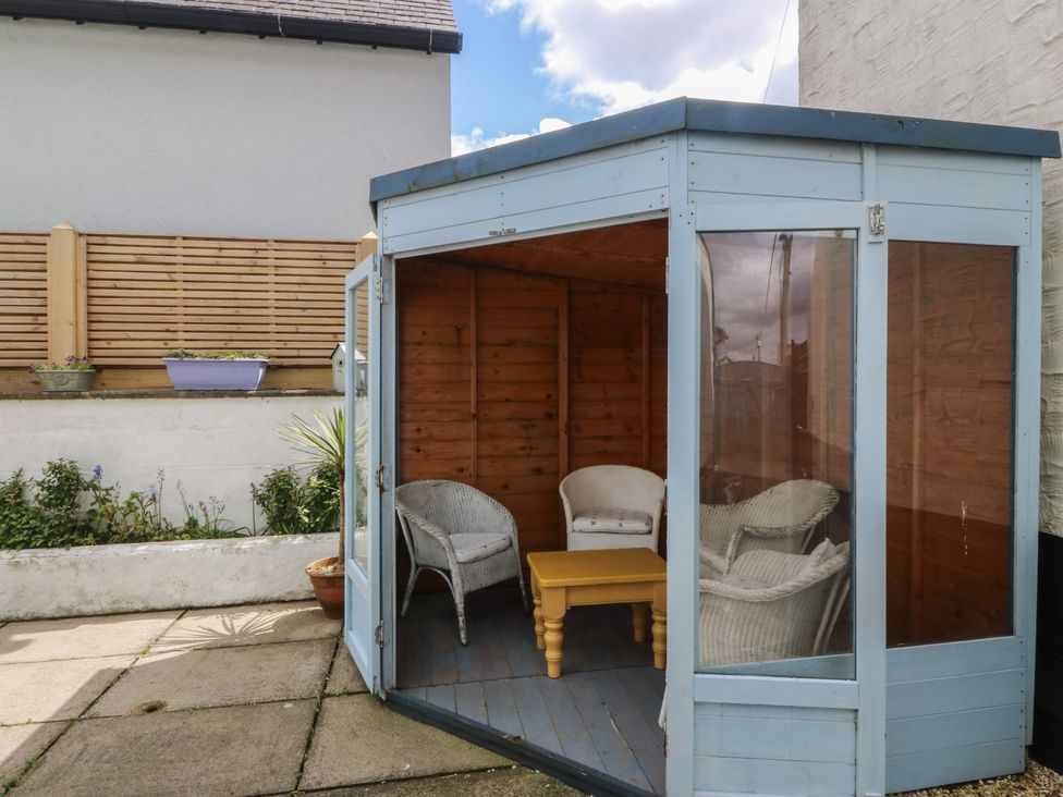 A garden structure with chairs and a table at Wingelock in Rhosneigr