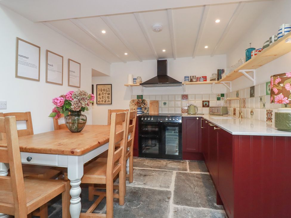 A kitchen with a dining table and wooden chairs at 84 Fore Street