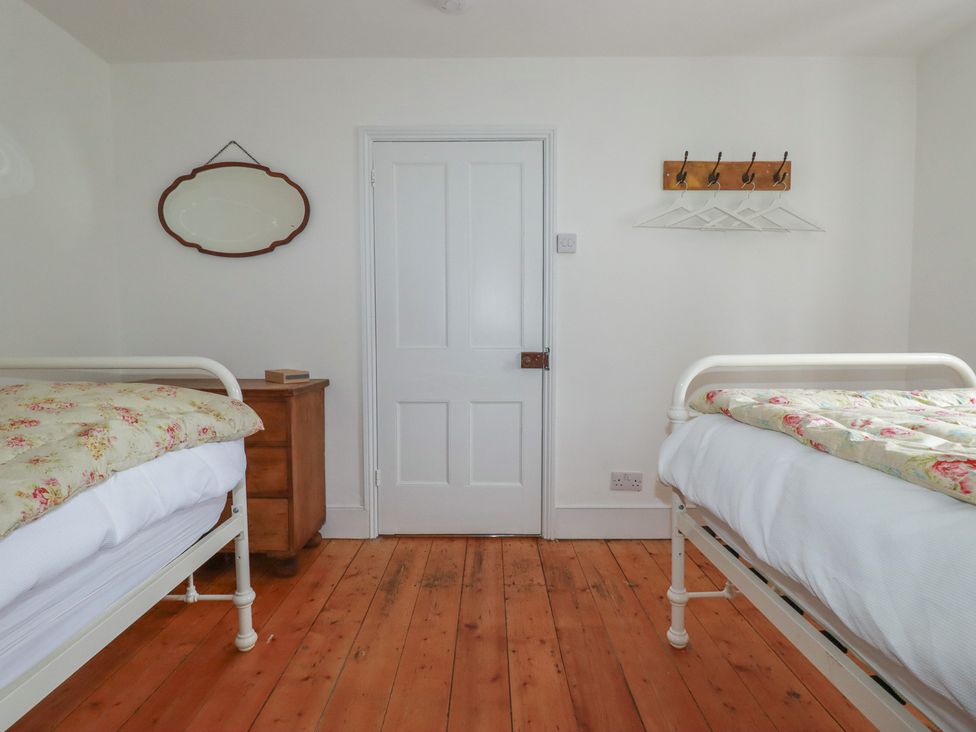 A bedroom with two beds and a door at 84 Fore Street