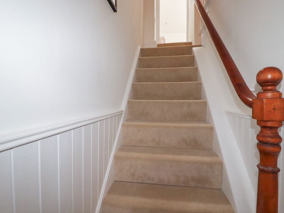 A staircase with carpet and handrail at 84 Fore Street