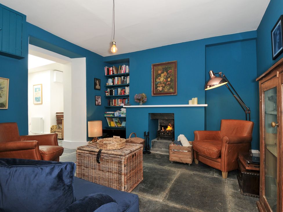 A living room with a fireplace and bookshelves at 84 Fore Street in Port Isaac