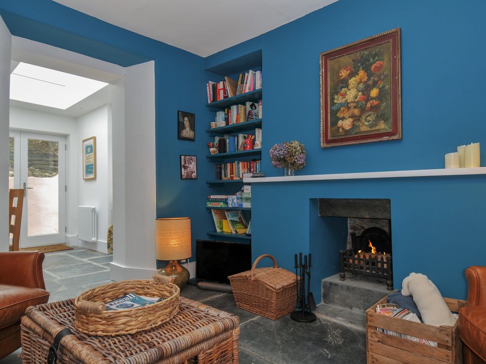 A living room with a bookshelf and fireplace at 84 Fore Street in Port Isaac