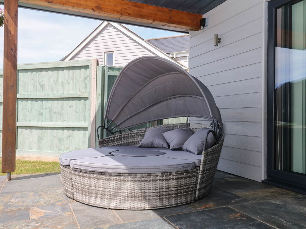 An outdoor sofa with a canopy at Harescombe Lodge in Morchard Bishop