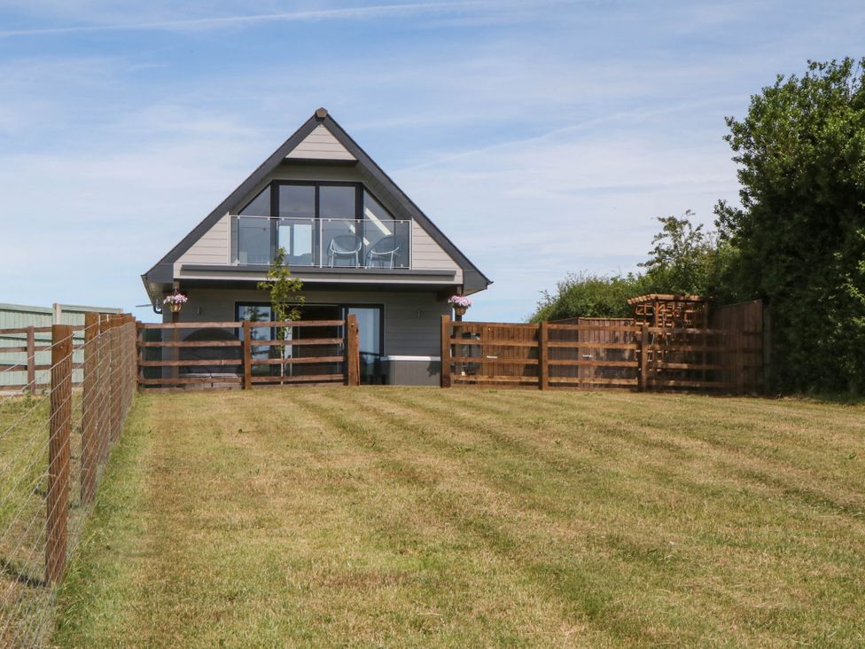 A house with a balcony and fence at Harescombe Lodge, Morchard Bishop
