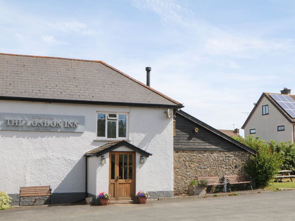 Exterior view of The London Inn with benches at The London Inn in Morchard Bishop