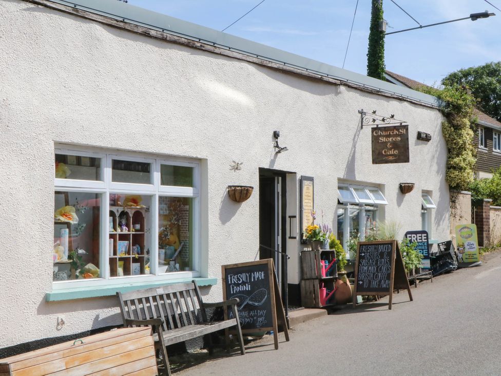 A store and cafe with benches and signage at Church St Stores in Morchard Bishop