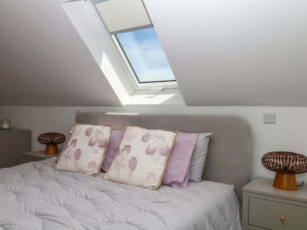 A bedroom featuring a bed with pillows and a bedside table at Harescombe Lodge in Morchard Bishop
