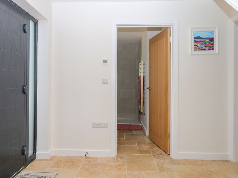 A hallway with a door and a bathroom access at Harescombe Lodge in Morchard Bishop