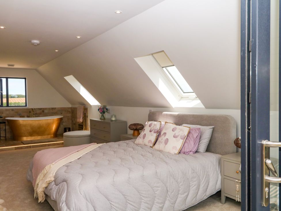 A bedroom with a bed and bathtub at Harescombe Lodge in Morchard Bishop