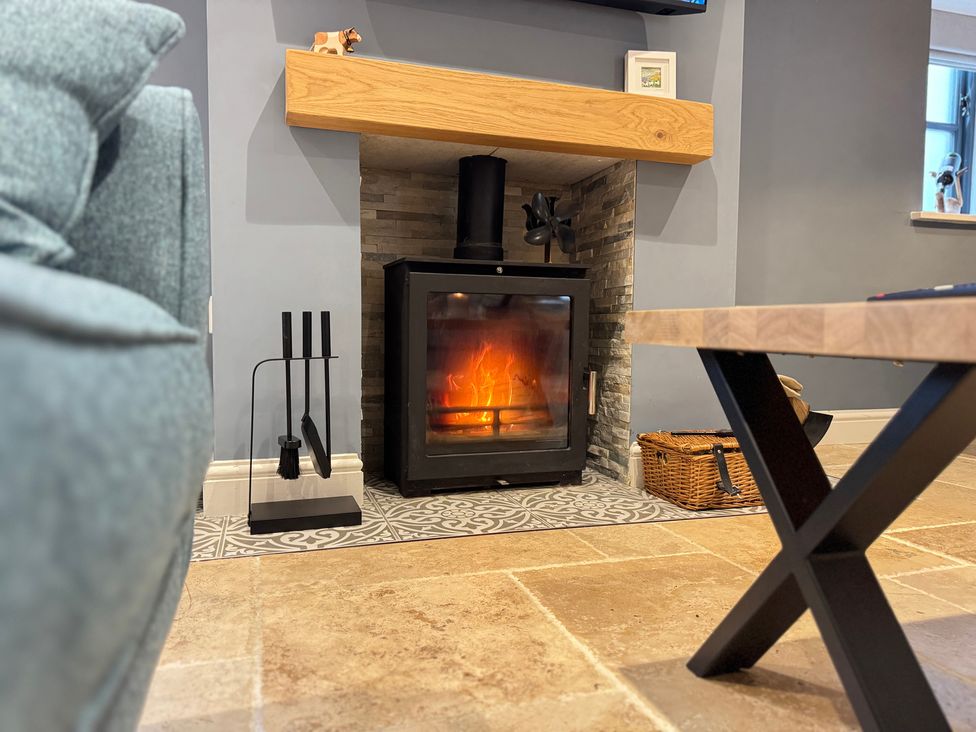 A living room with a fireplace and coffee table at Railway Cottage in Penybontfawr
