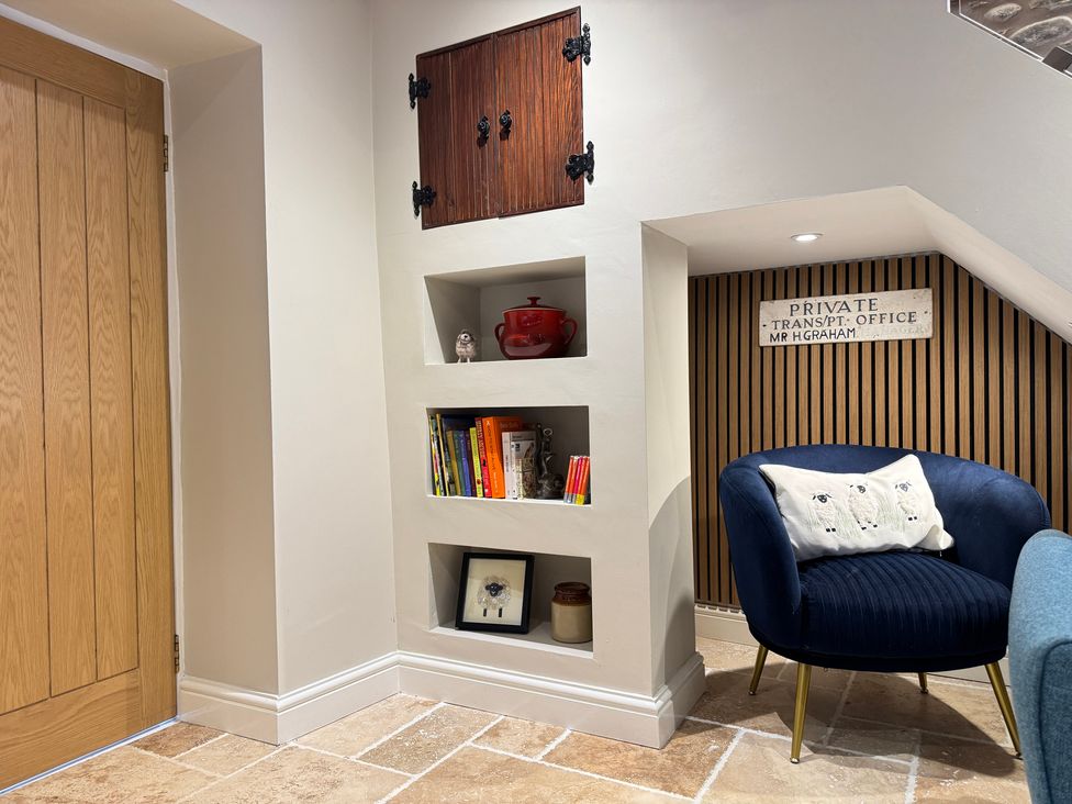 An office space with shelves and a blue chair at Railway Cottage in Penybontfawr