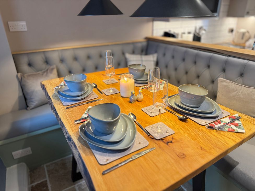 A dining room with a table set for meals at Railway Cottage Penybontfawr