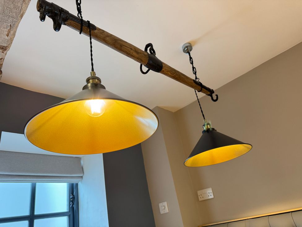 A ceiling with hanging lights and a wooden beam at Railway Cottage in Penybontfawr