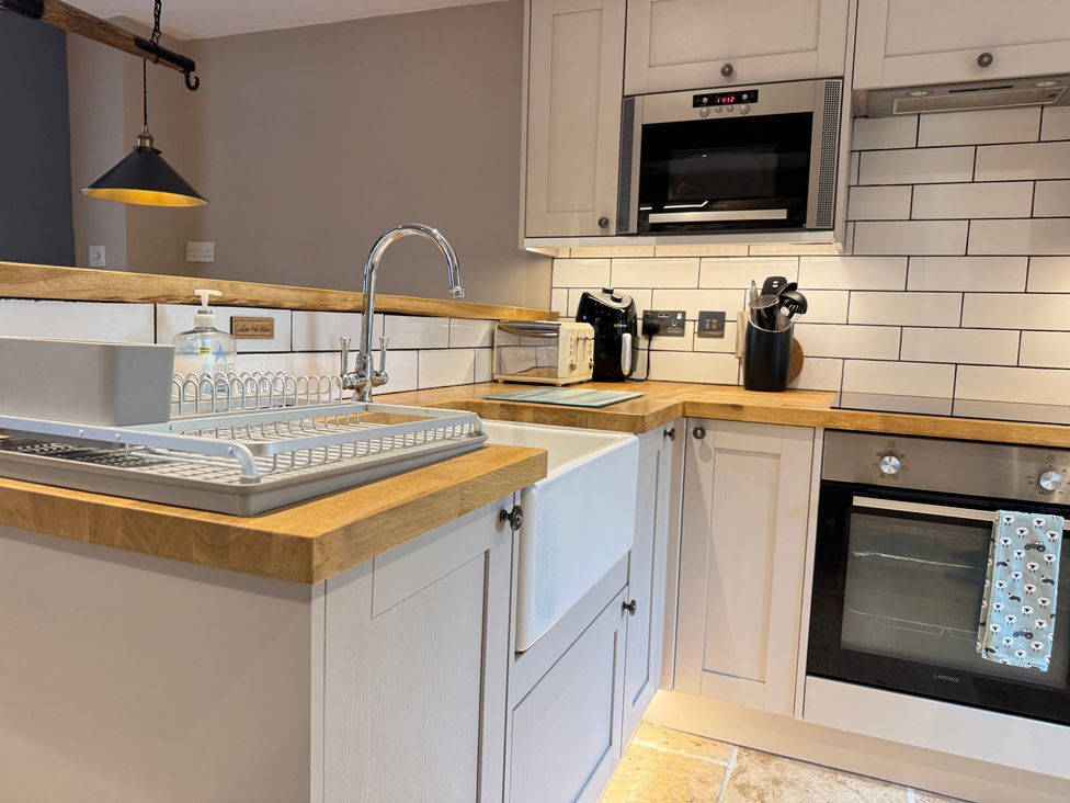 A kitchen with sink and oven at Railway Cottage in Penybontfawr