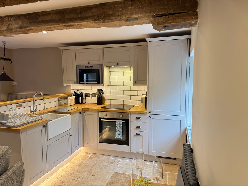 A kitchen with a sink, oven, and microwave at Railway Cottage in Penybontfawr