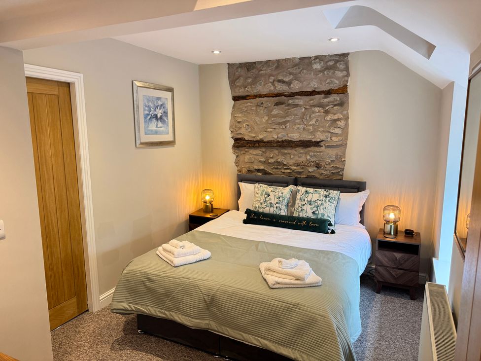A bedroom with a bed and bedside tables at Railway Cottage in Penybontfawr