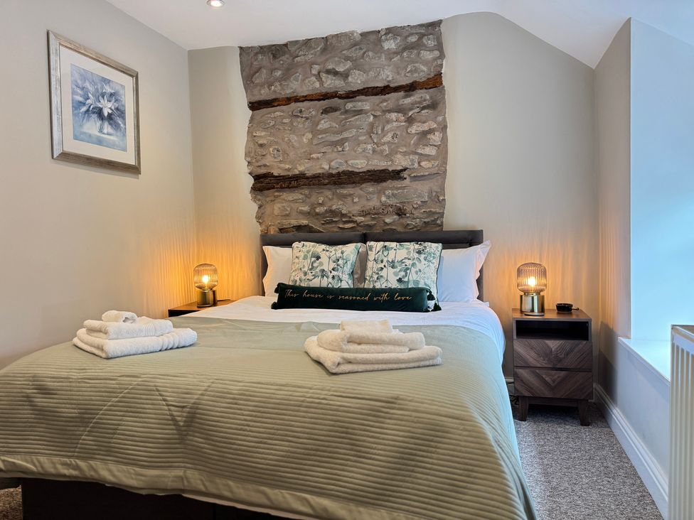A bedroom with a bed and wall art at Railway Cottage Penybontfawr