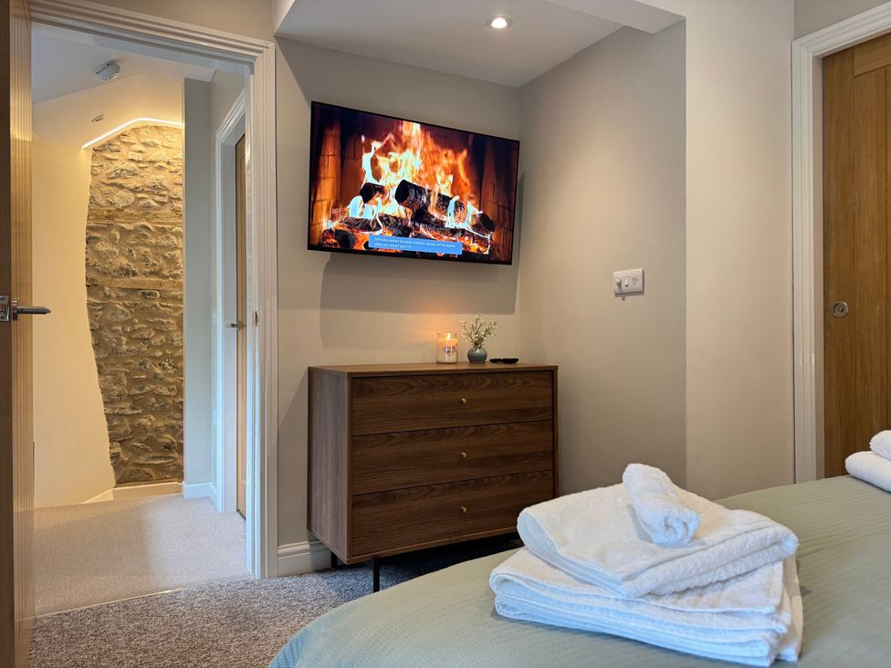 A bedroom featuring a television and dresser at Railway Cottage Penybontfawr