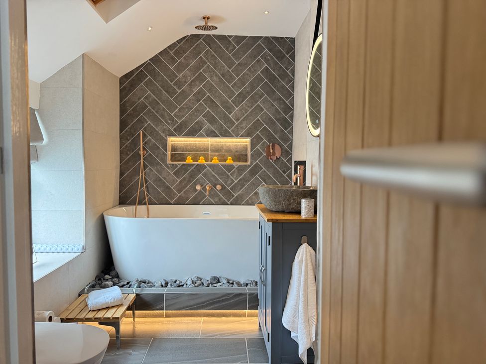 A bathroom with a bathtub and sink at Railway Cottage Penybontfawr