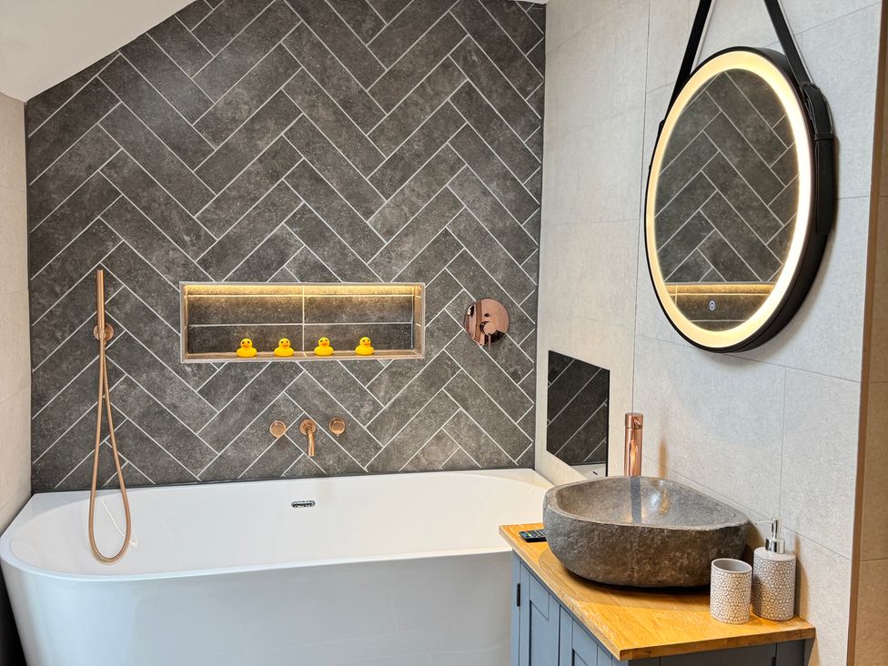 A bathroom with a bathtub and sink at Railway Cottage in Penybontfawr