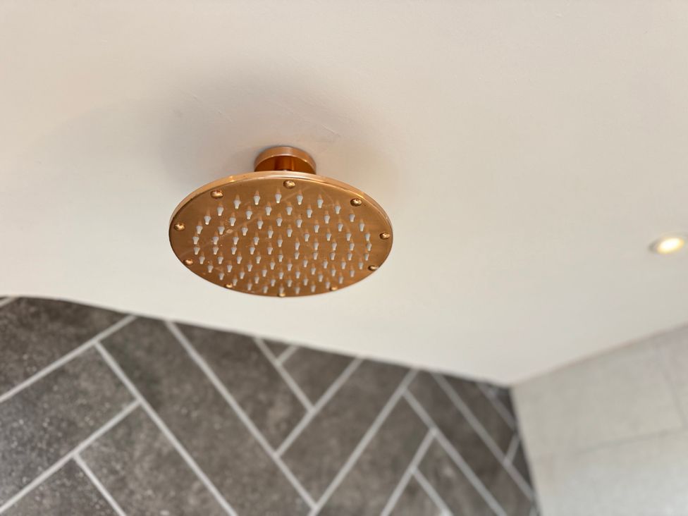 A shower head in a bathroom at Railway Cottage in Penybontfawr