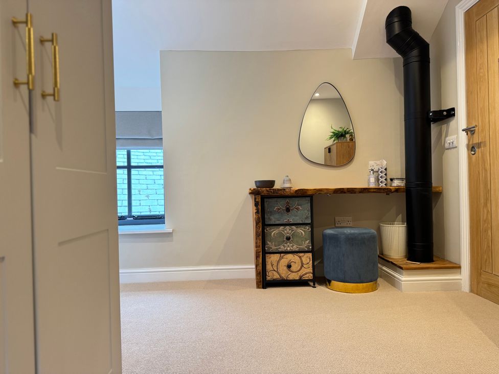 A room with a table and mirror at Railway Cottage in Penybontfawr