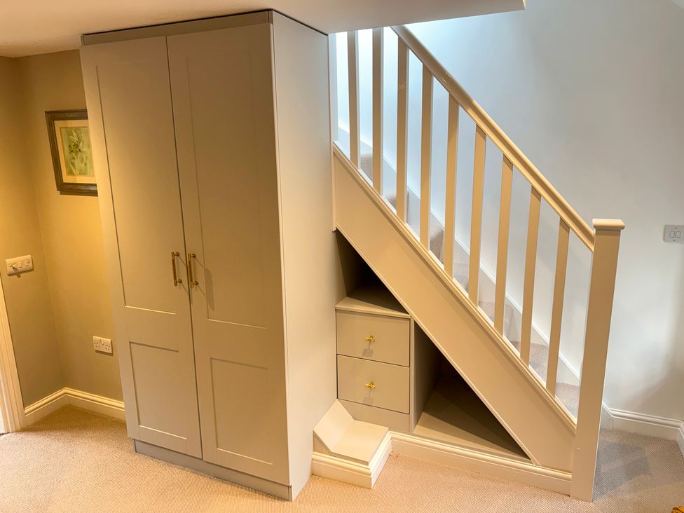 A stairwell with a wardrobe and drawers at Railway Cottage in Penybontfawr