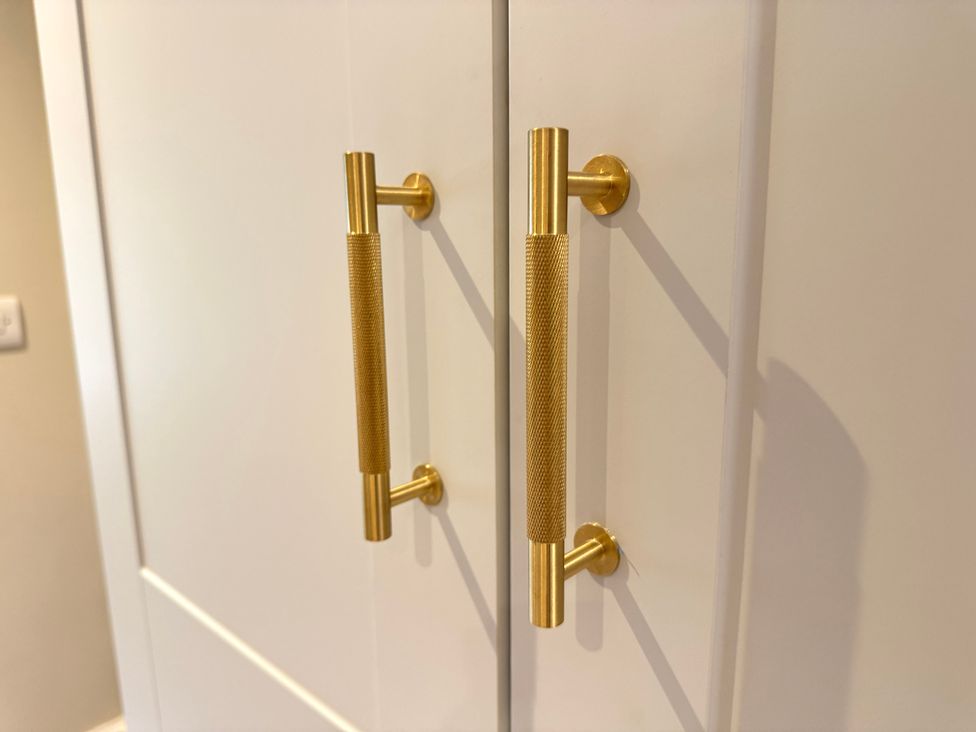 Cabinet doors with gold handles at Railway Cottage in Penybontfawr