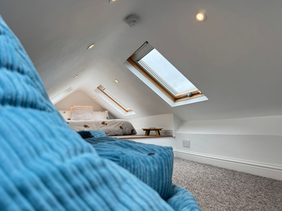 A bedroom with a bed and skylights at Railway Cottage in Penybontfawr