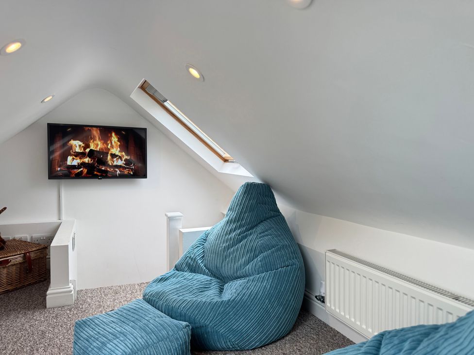 A seating area with a television showing a fireplace at Railway Cottage in Penybontfawr