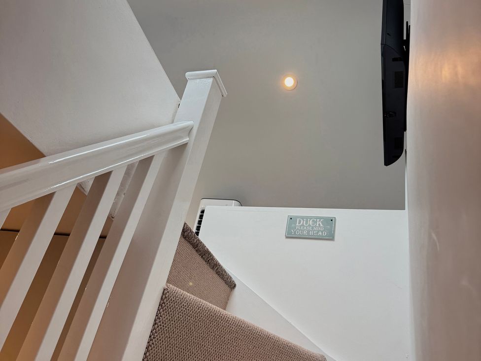 A staircase with a handrail and a sign at Railway Cottage in Penybontfawr
