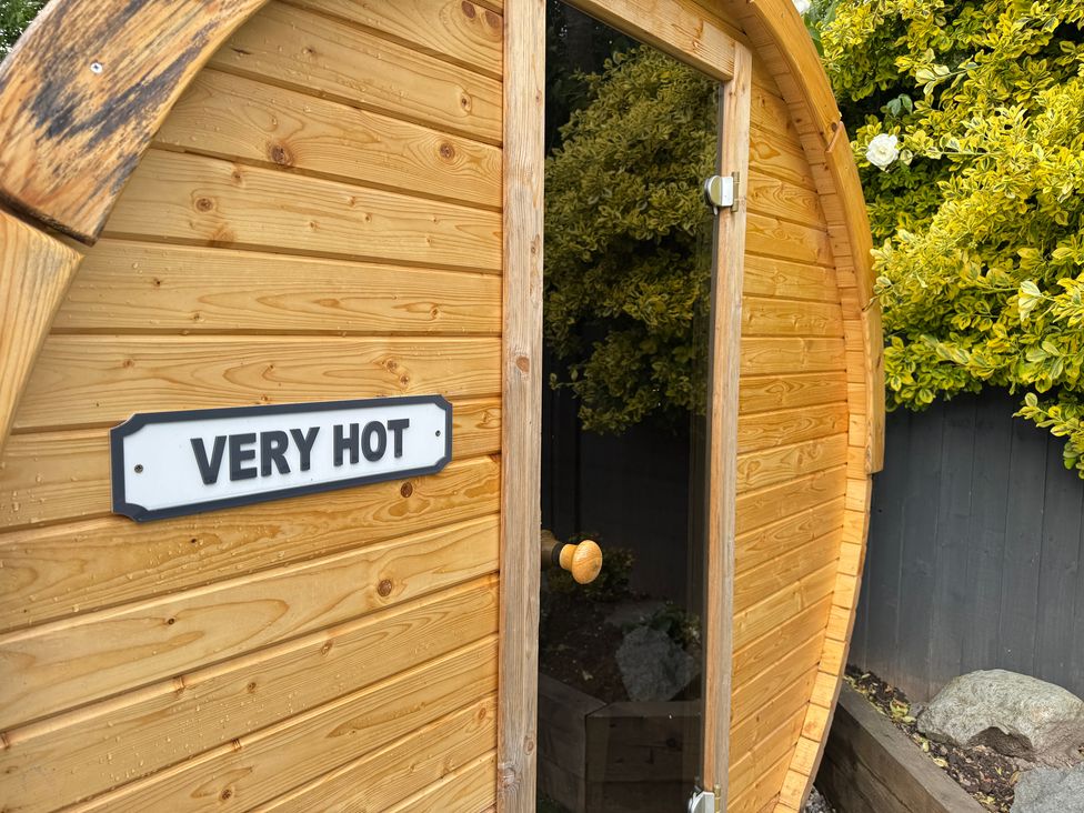 A wooden structure with a door and sign in an outdoor area at Railway Cottage Penybontfawr