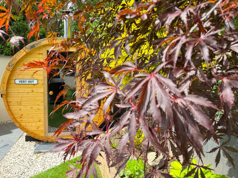 A wooden hot tub in a garden at Railway Cottage Penybontfawr