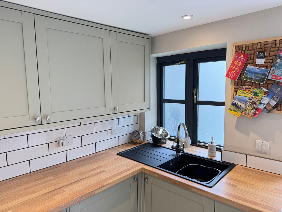 A kitchen with a sink and cabinets at Railway Cottage in Penybontfawr