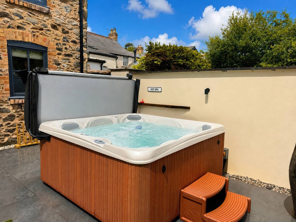 A hot tub with steps in an outdoor space at Railway Cottage Penybontfawr