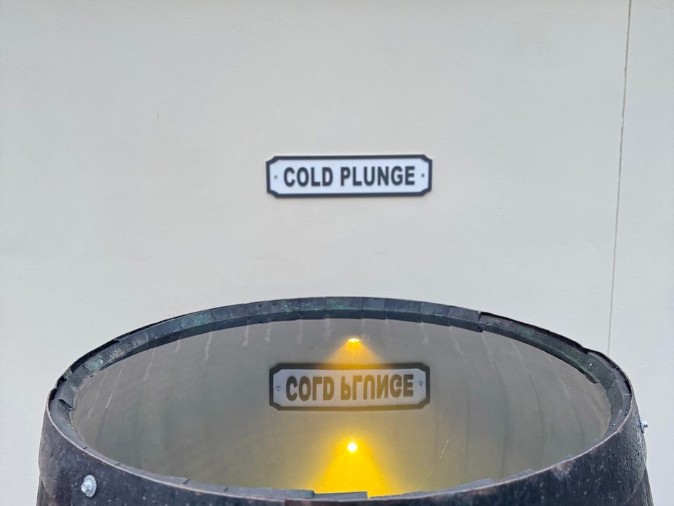 A cold plunge pool with a sign at Railway Cottage in Penybontfawr