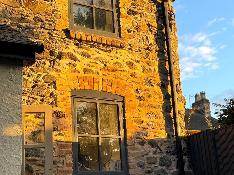 A stone exterior with windows and brick arch at Railway Cottage Penybontfawr
