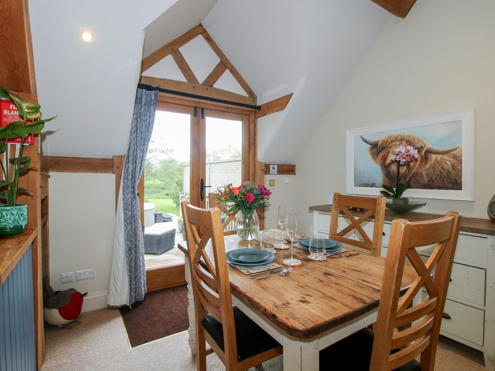 A dining room with a wooden table and chairs at Pultheley Cottage in Hyssington near Churchstoke