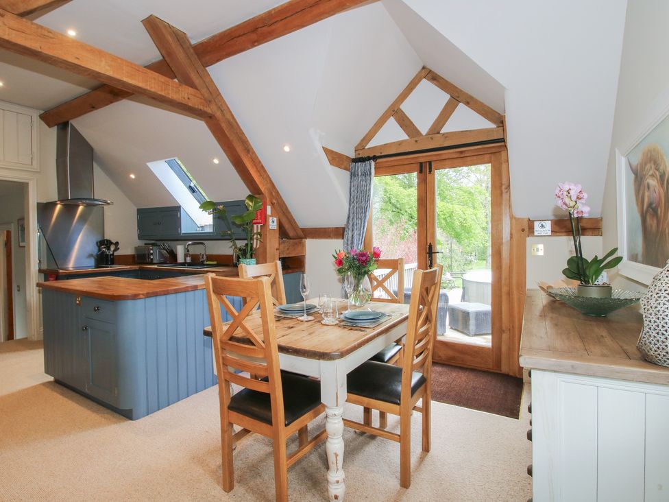A kitchen with a dining table and chairs at Pultheley Cottage in Hyssington near Churchstoke