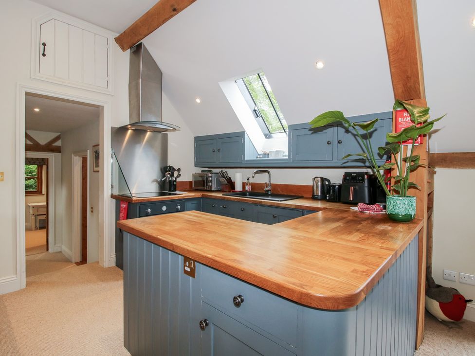 A kitchen with wooden countertops and blue cabinets at Pultheley Cottage Hyssington near Churchstoke